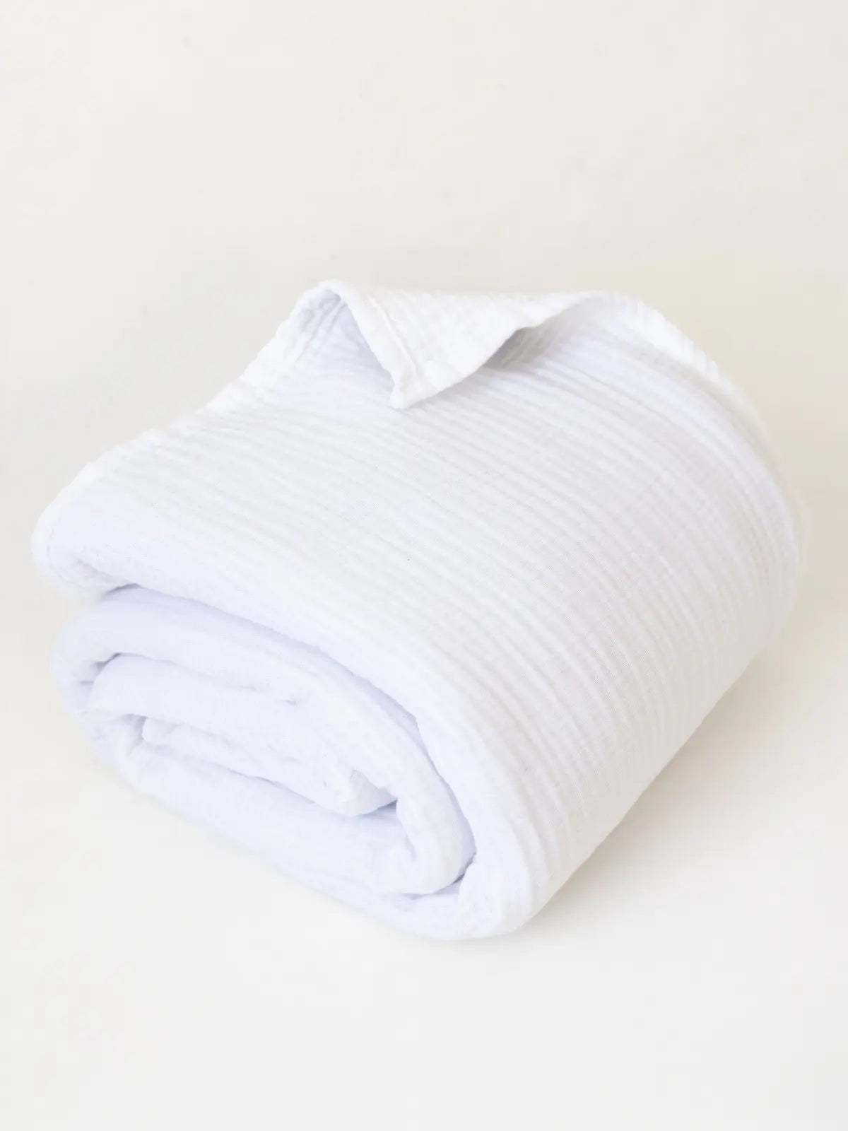 Beyaz muslin saçaksız pike katlanmış halde düz kenar detayı