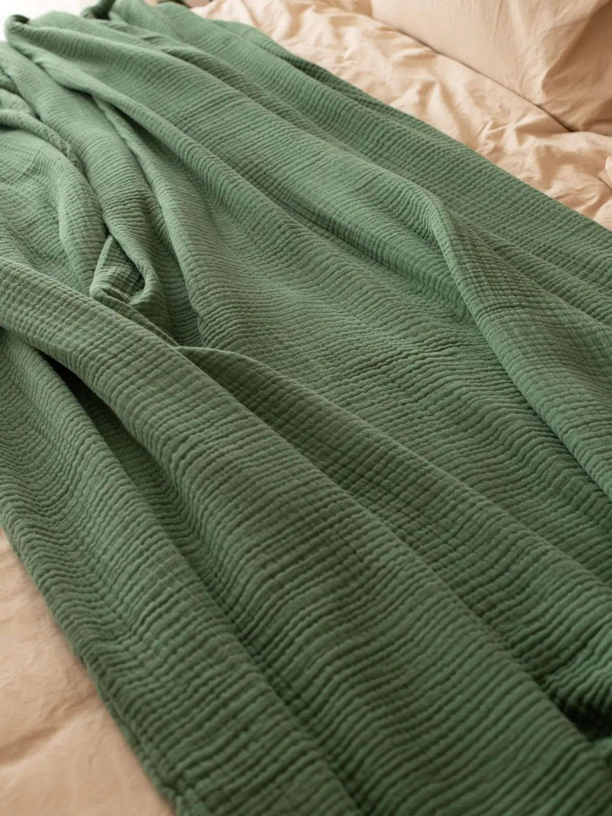 Koyu yeşil muslin saçaksız pike katlanmış halde düz kenar detayı