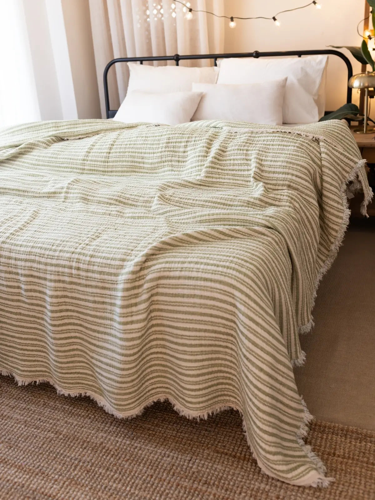 Yeşil çizgili müslin yorgan geniş açı yatak odası görünümü