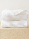 Beyaz pamuklu waffle havlu simetrik katlanmış düzen