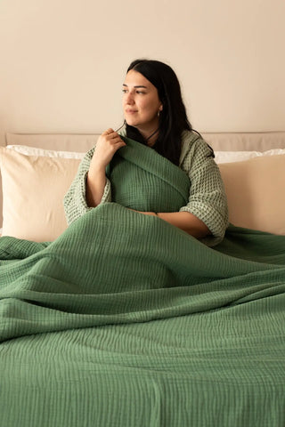 handwoven-4-layer-muslin-natural-bedspread-dark-green-folded-flat-lay-vivamaison