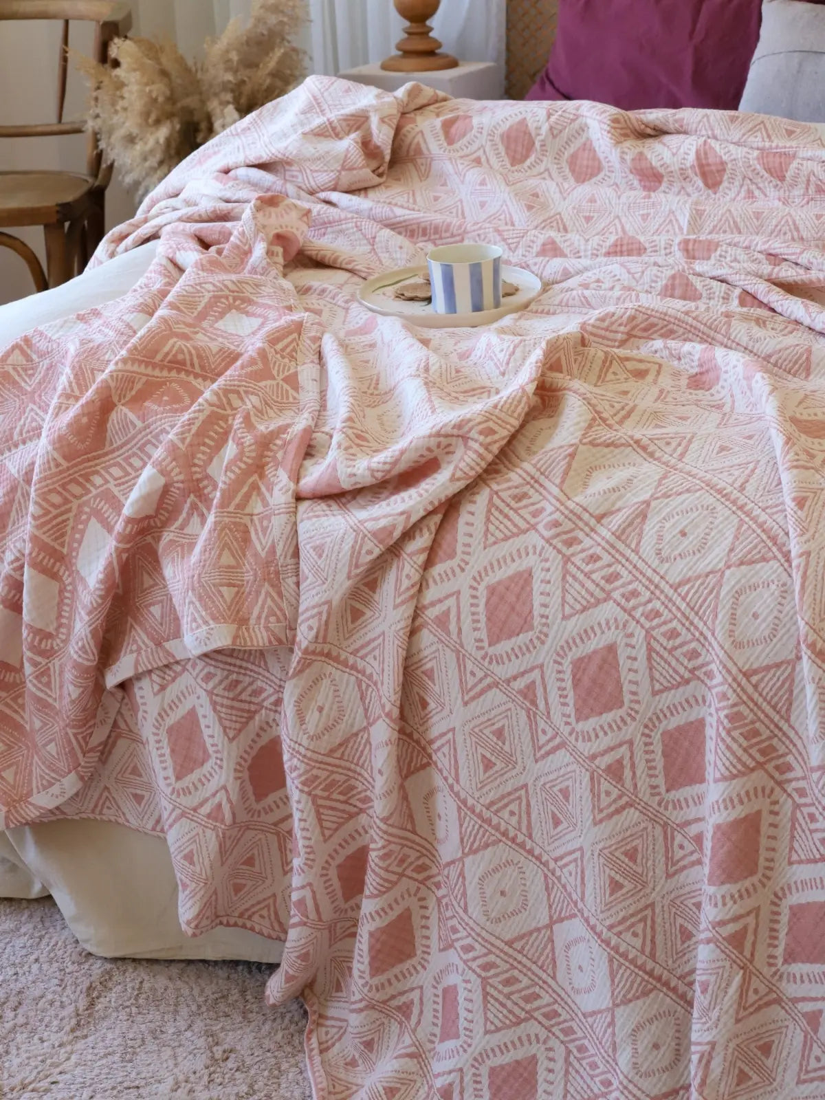 Etnik pembe desenli jakarlı muslin yatak örtüsü katlanmış halde motif detayı