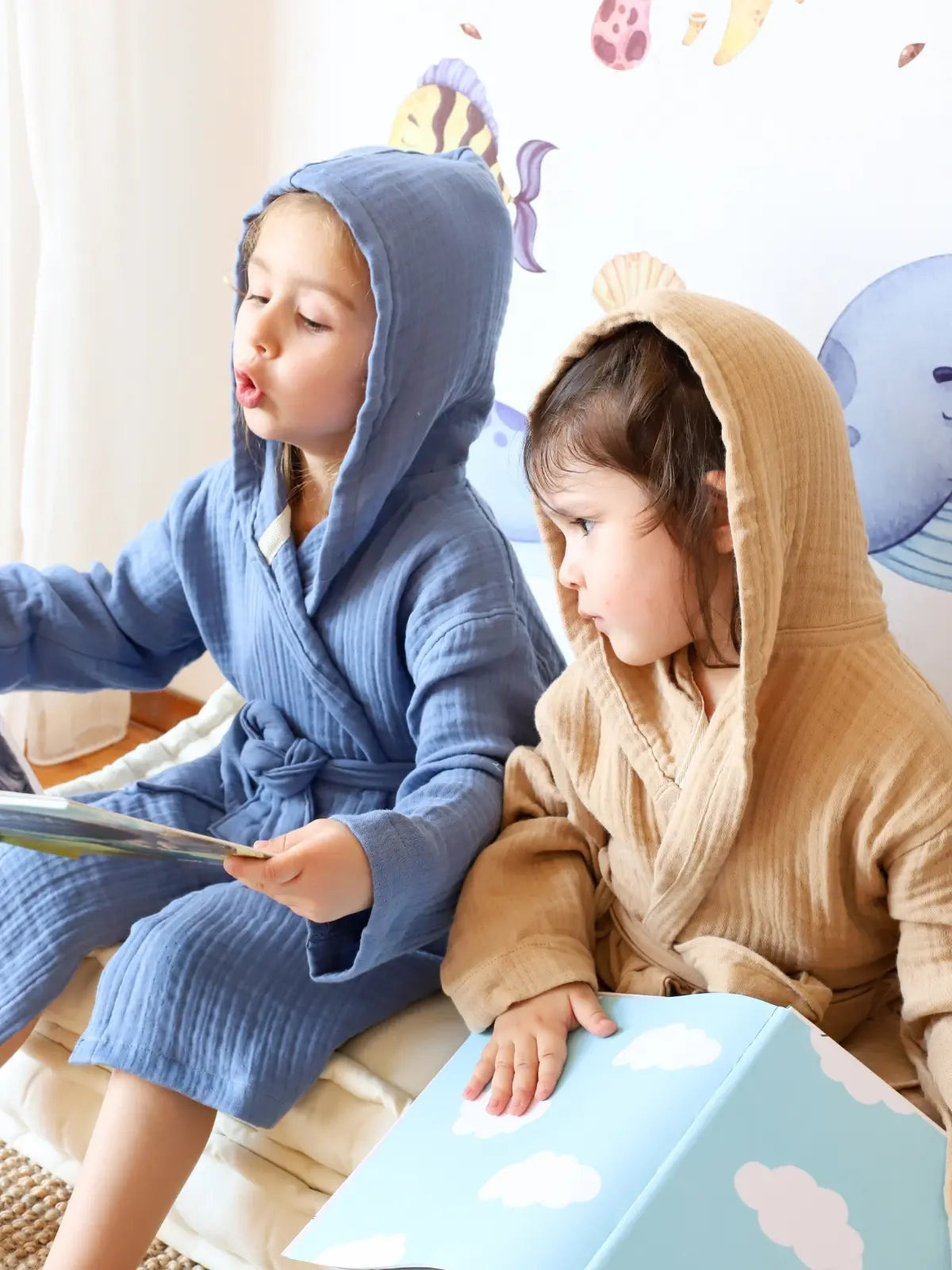 İndigo mavi ve açık kahve muslin bebek bornozu iki çocuk model oturur poz