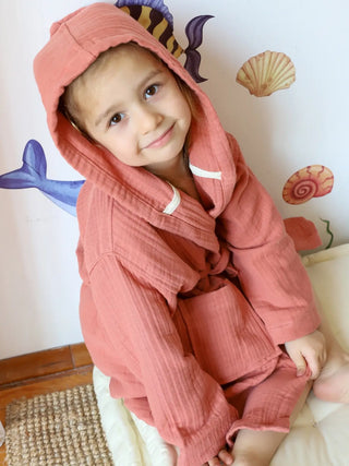 Terracotta müslin bebek bornozu giyili çocuk model oturur poz