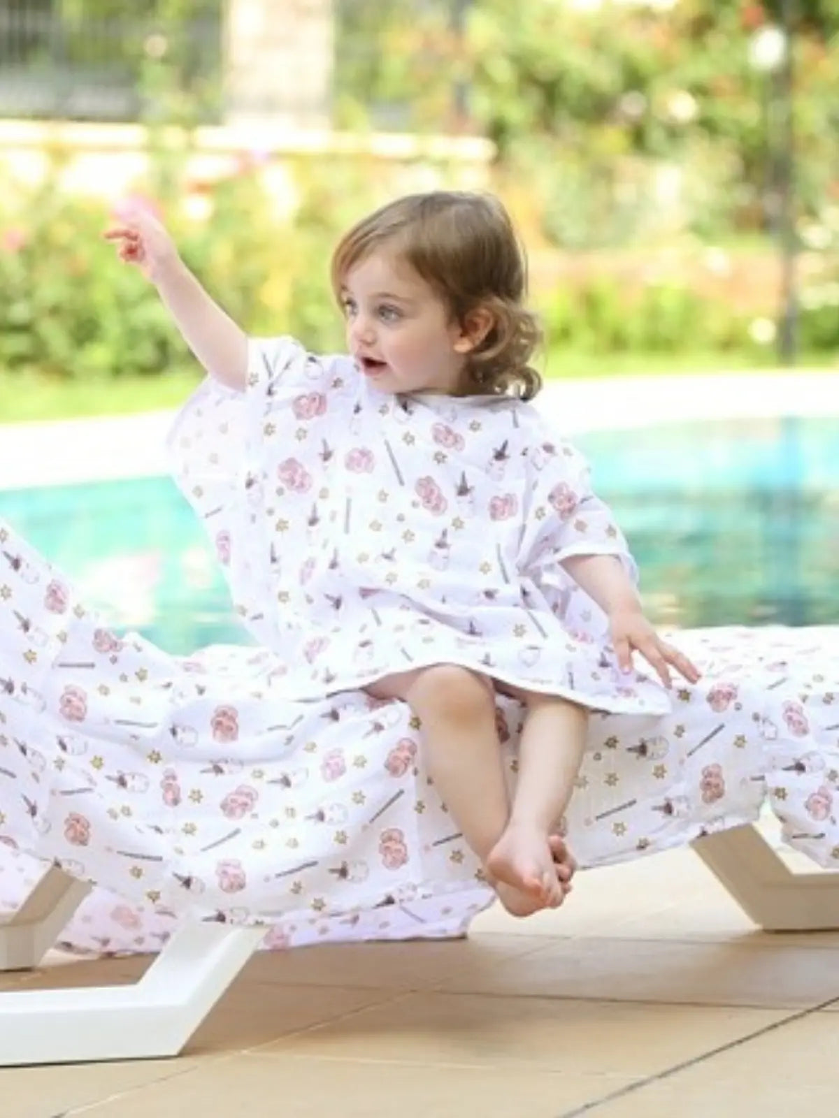 Tek boynuzlu at desenli muslin bebek panço giyili çocuk model oturur başka açı poz 